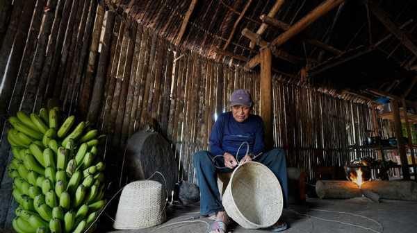 An elder weaver in a forest house